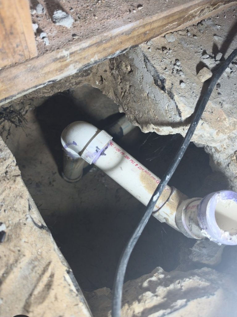 Plumbing trench cut into the concrete slab during a Delray Beach bathroom remodel by Onel Construction