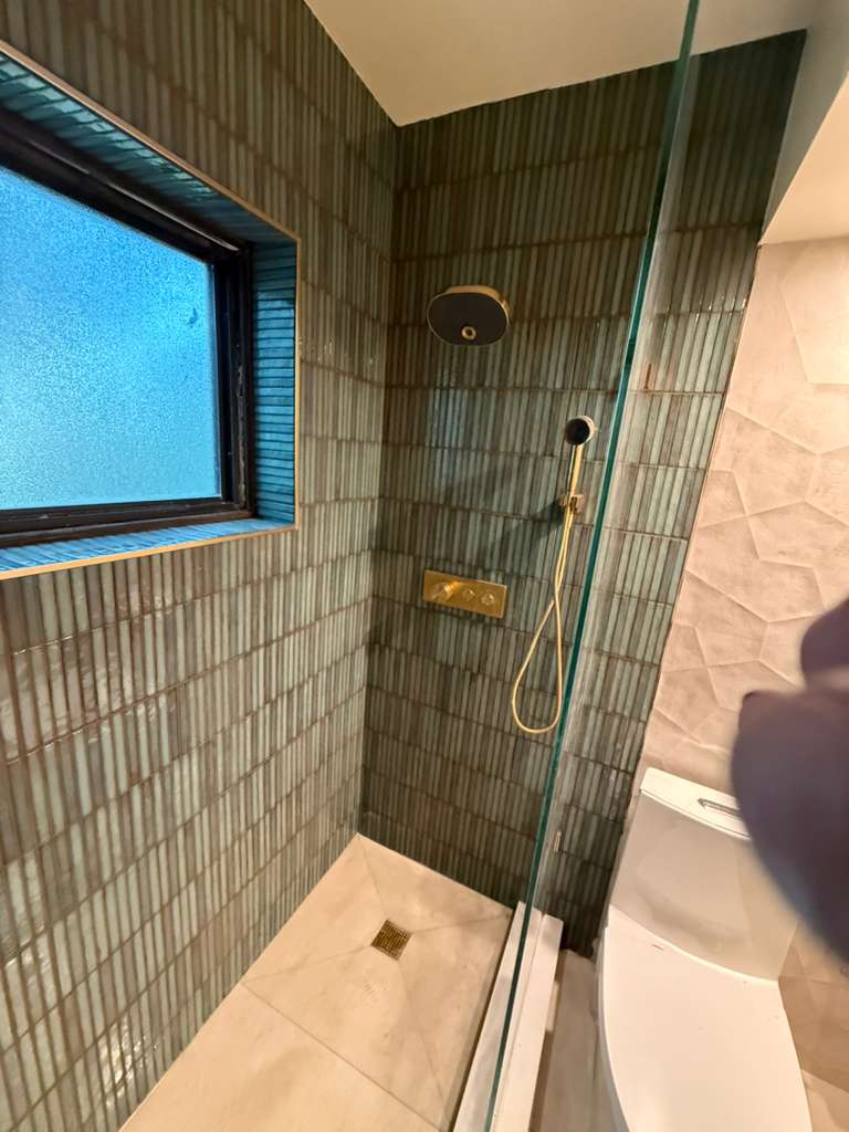 finished walk-in shower with bench and glass enclosure